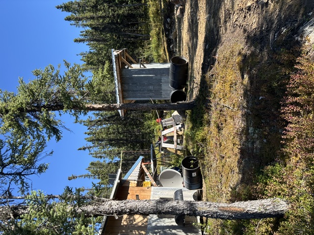 Right-side exterior of the cabin, with the outhouse behind