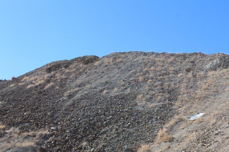 Angular waste-rock talus spilling below an altered outcrop