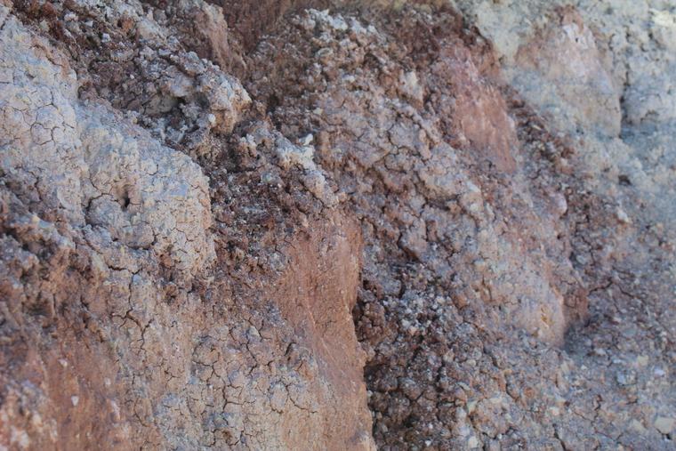 Deep orange-red iron oxide on weathered fracture surfaces