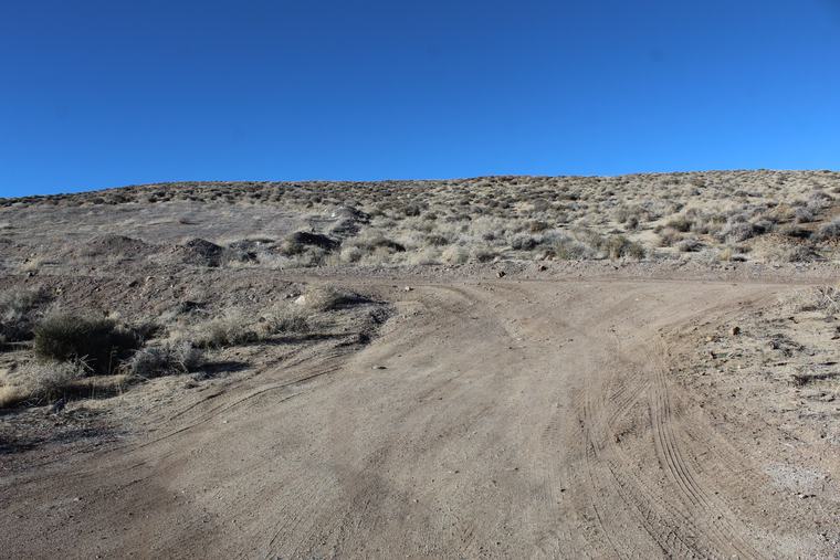 Two-track curving up a bare hillside toward the upper workings
