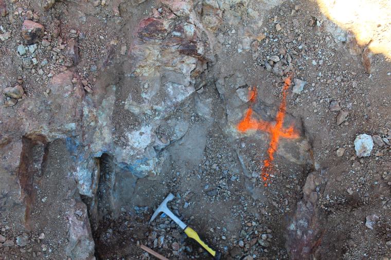 Outcrop marked with a spray-painted sample number, copper visible in the crevice