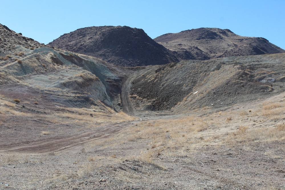Dirt-road access cut into altered skarn bedrock leading to historic workings